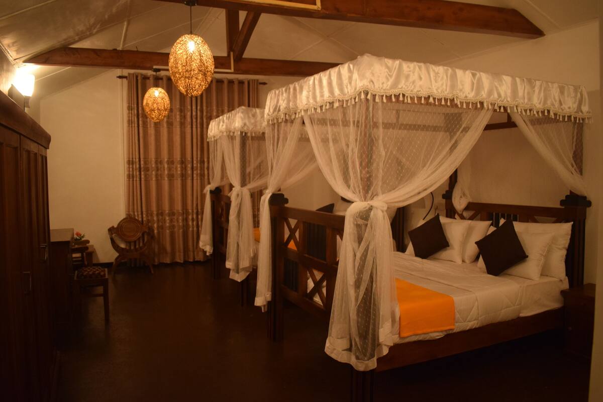 Ein traditionell eingerichtetes Zimmer mit Himmelbett, Holzmöbeln und Hängeleuchten.
