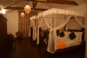 Una habitación tradicional con cama con dosel, muebles de madera y lámparas colgantes.