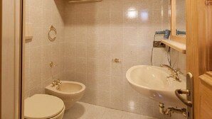 A small bathroom with a toilet, bidet, and sink.