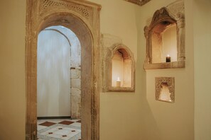 An arched doorway leading to a room with a tiled floor and a candle in a window. - Porta Medina Boutique Hotel - Adults Only (Heraklion)