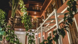 A multi-story building with a balcony, wooden railings, and a staircase.