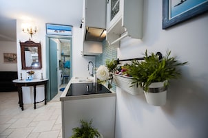 A modern kitchen with a built-in sink, a wooden table, and a potted plant.