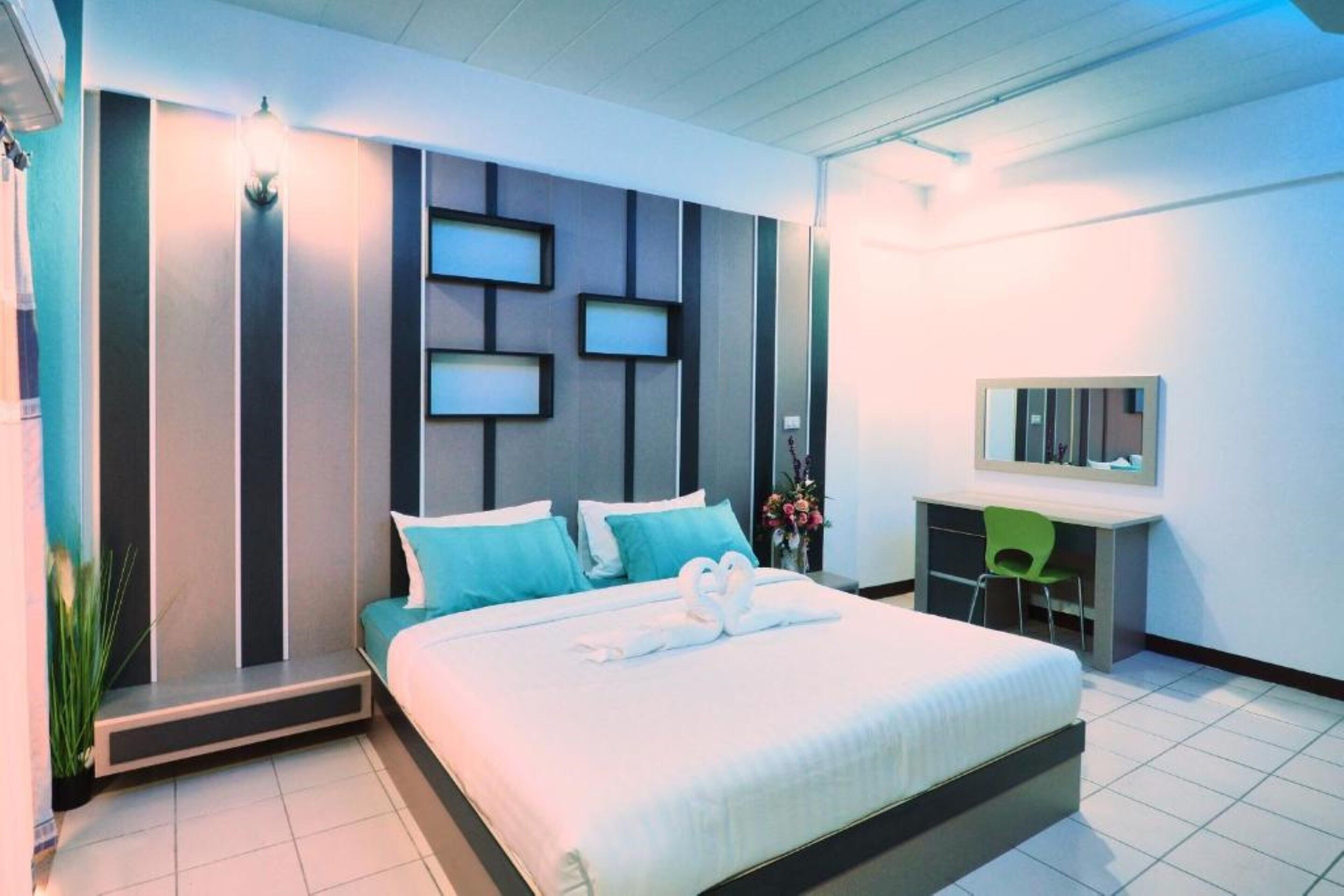 Une chambre d’hôtel moderne, dotée d’un grand lit, d’un bureau et d’une chaise.