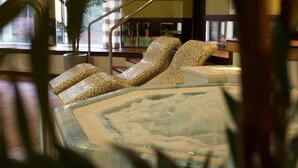 Un área de spa con un jacuzzi y dos sillas reclinables.