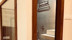Une salle de bain moderne avec une paroi en verre, un porte-serviettes et des toilettes.