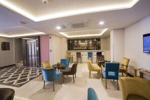 A hotel lobby with a bar area, seating, and an elevator. - The Meretto Hotel Laleli (Istanbul)