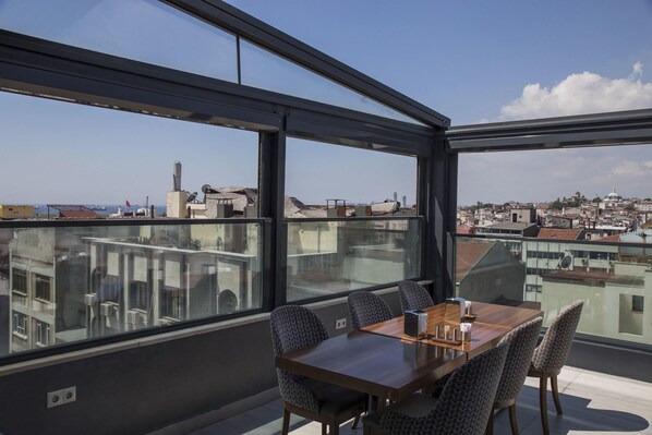 A modern dining area with a panoramic city view, large windows, and contemporary furniture. - The Meretto Hotel Laleli (Istanbul)