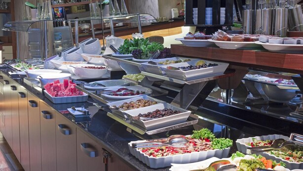 Un bufé con diversos alimentos y utensilios.