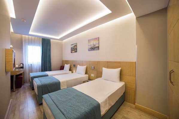 A hotel room with two beds, a desk, and a window with curtains. - The Meretto Hotel Laleli (Istanbul)