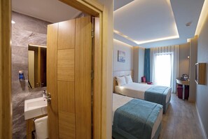 A hotel room with a wooden wardrobe, a bed, a bedside table, a mirror, a sink, and a window with curtains. - The Meretto Hotel Laleli (Istanbul)
