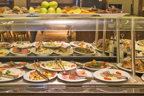 A buffet with various dishes and utensils. - The Meretto Hotel Laleli (Istanbul)