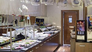A buffet area with various food options, a staff-only door, and a beverage dispenser.