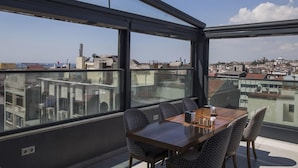 Un comedor moderno con vistas panorámicas de la ciudad, ventanas amplias y muebles contemporáneos.