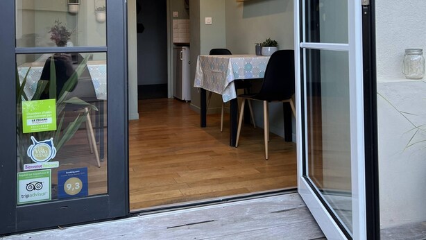 Ein modernes Interieur mit Essbereich, einer Küche und einem Glastür-Eingang.