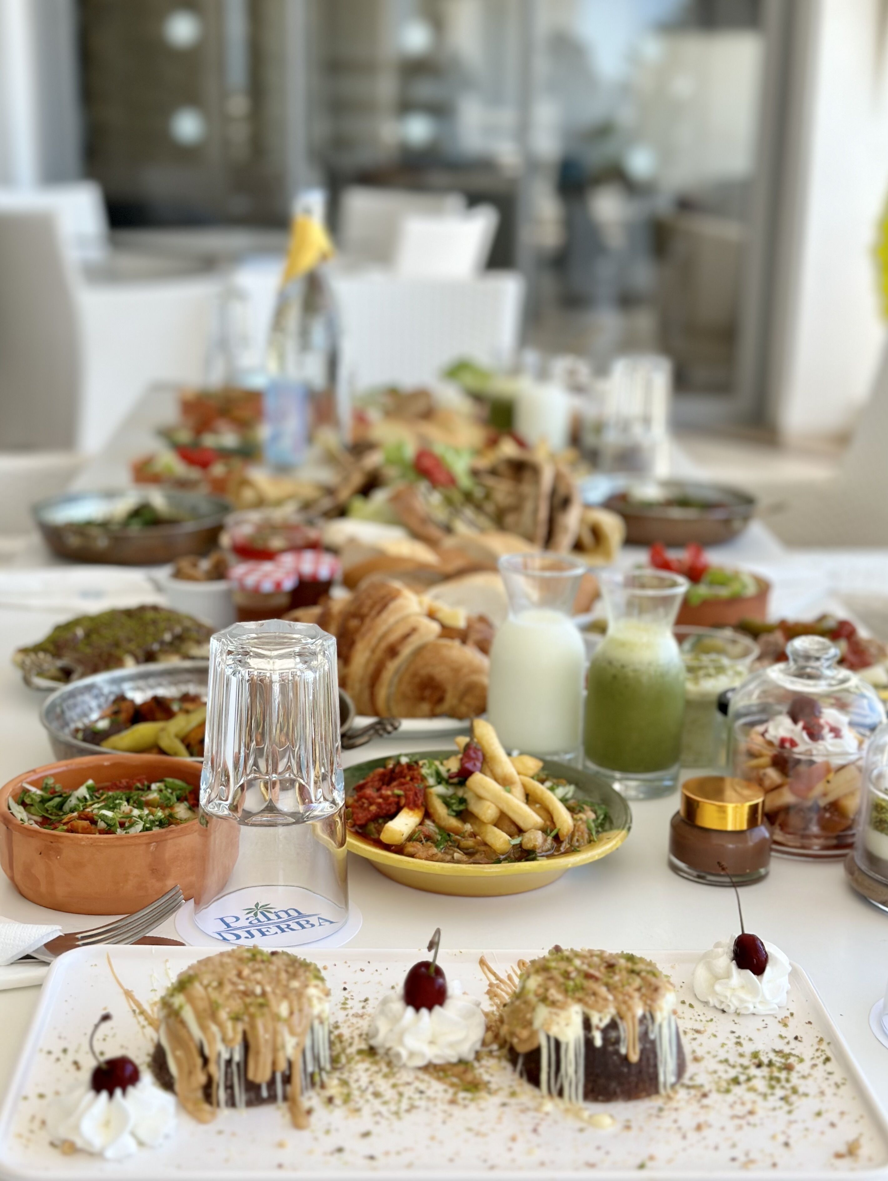 A buffet table with various dishes, including salads, pastries, and desserts.