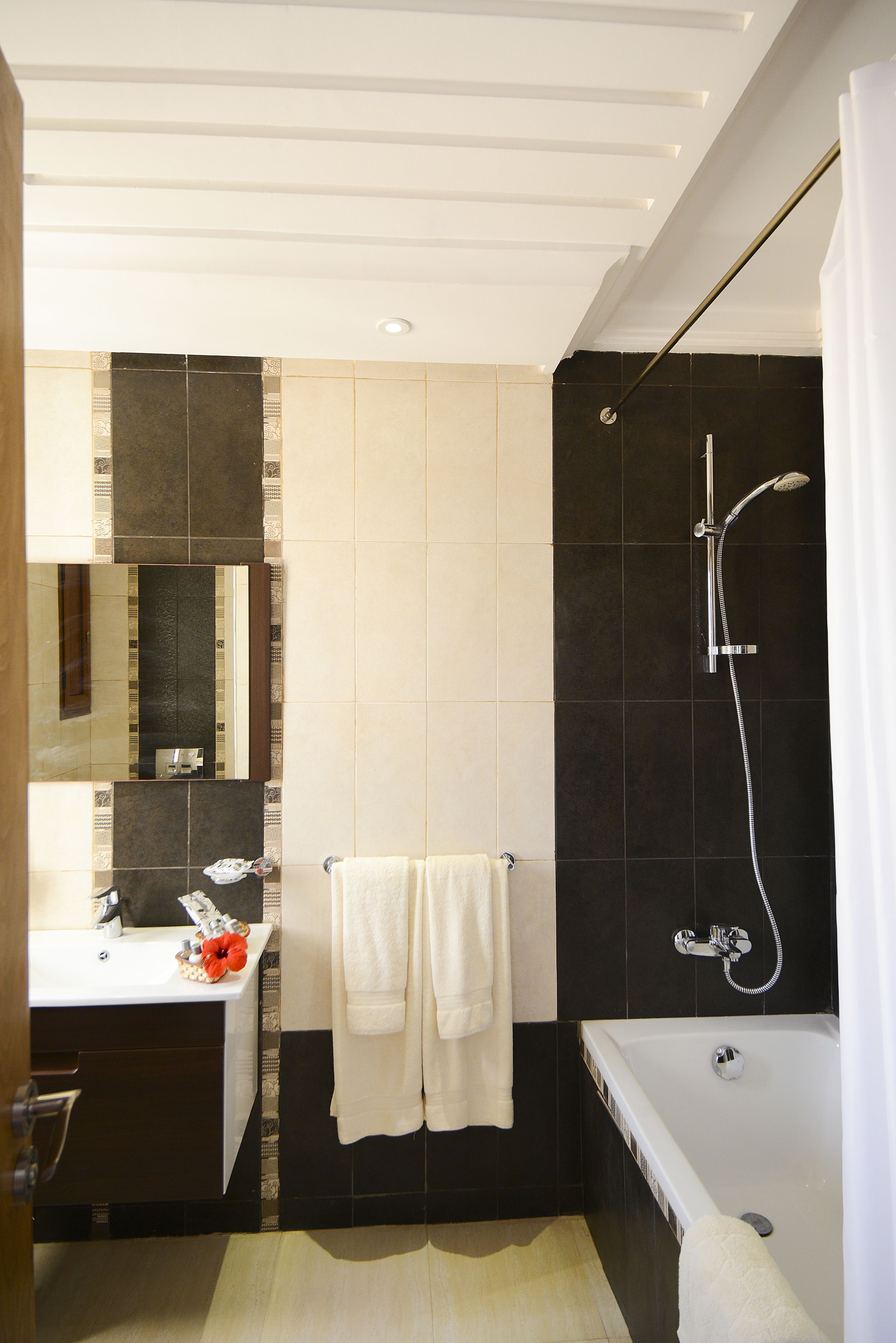 A modern bathroom with a bathtub, shower, and sink.