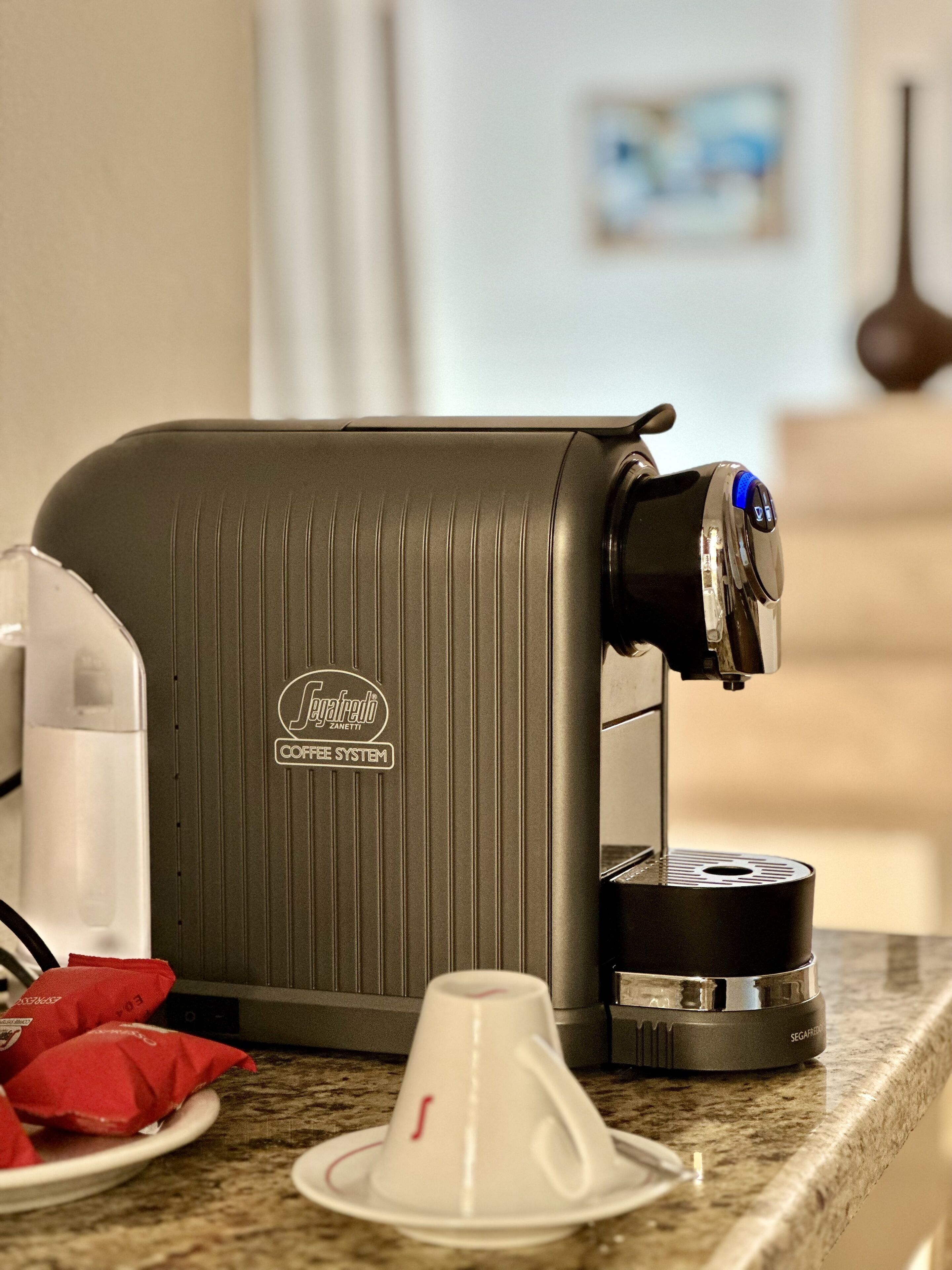 A coffee machine with a control panel and a cup holder.