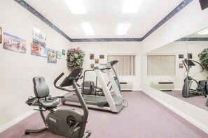 A fitness room with treadmills, an elliptical, and a stationary bike. - Baymont Inn and Suites (Corbin)
