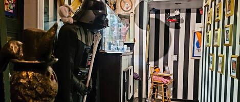 A room with a checkered floor, a Star Wars figure, and a small table with a chair.