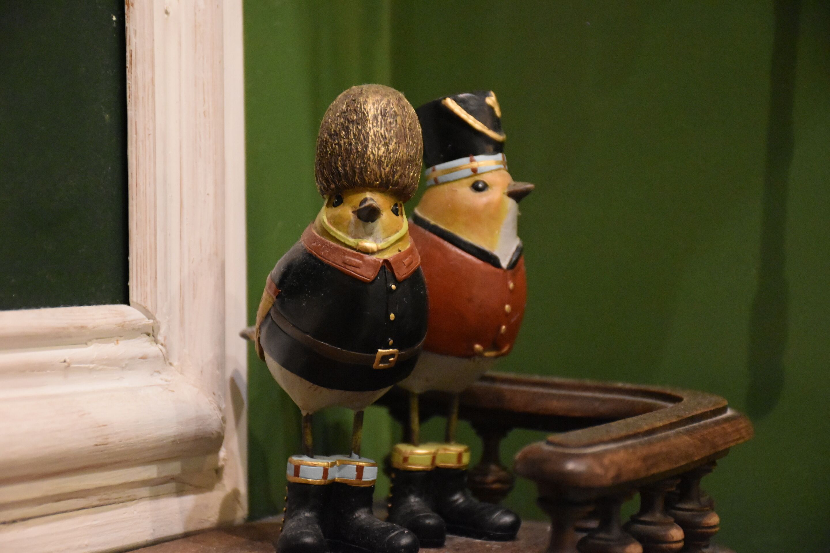 Duas figuras de soldados em madeira em uma prateleira.