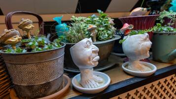 Verschillende potplanten en decoratieve beeldjes op een plank.