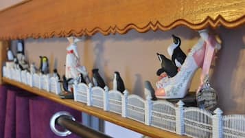 Una estantería con figuras de pingüinos y un enrejado decorativo.