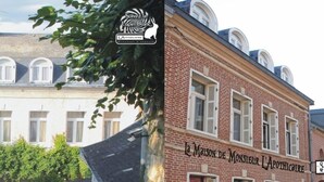 A two-story building with a sign reading "La Maison de Monseigneur L'APOTHICAIRE."
