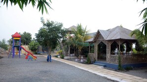 A playground with a slide and climbing structures, a gazebo, and a small pavilion. - Wild Wadi Cottages Resort (Mendarda)