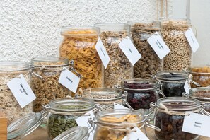 A variety of glass jars with labels, containing different types of grains and seeds.