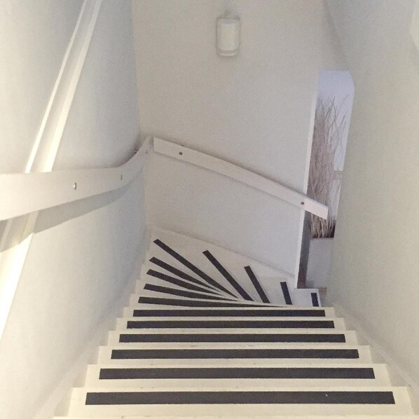 A staircase with white steps and black risers, leading upwards.