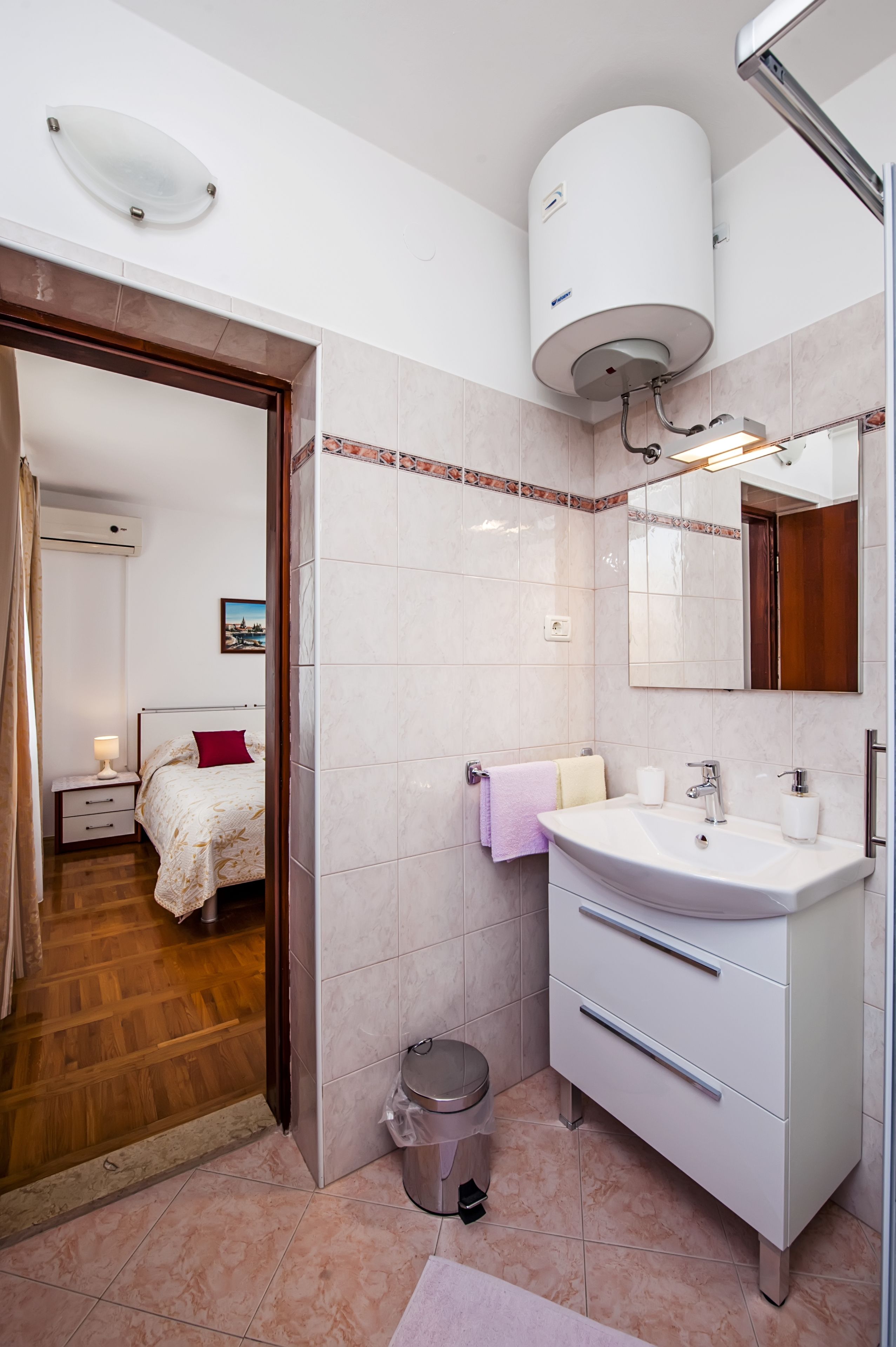 Uma casa de banho moderna com uma pia, espelho e sanita.