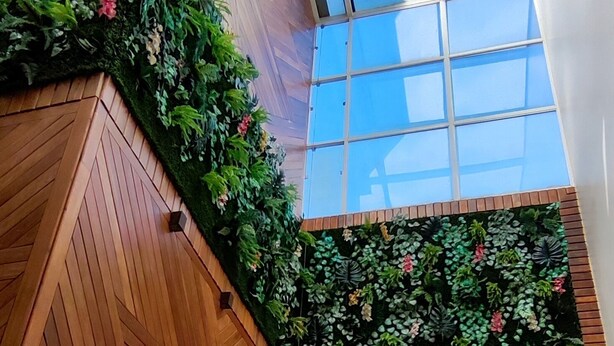 A modern interior with wooden paneling and a green wall with plants. - Hotel Sudoeste (Goiania)