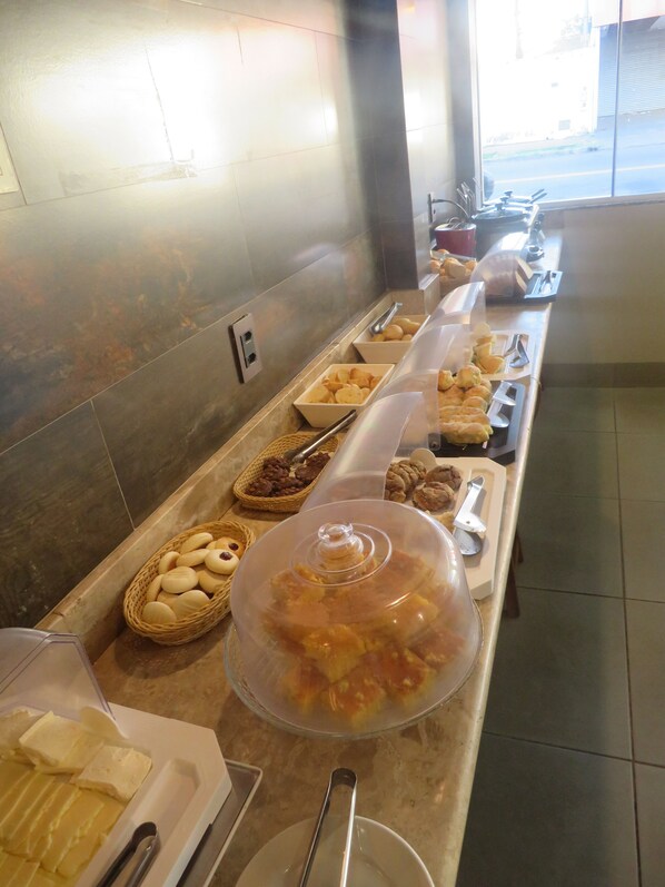 A buffet with various food items and utensils. - Hotel Sudoeste (Goiania)