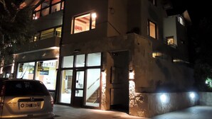 En byggnad med flera våningar, där bottenvåningen inrymmer en butik och en trappa leder upp till de övre våningarna.