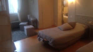 Un dormitorio con cama, escritorio, silla y armario.