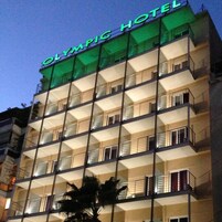 Un edificio de varios pisos con balcones y un letrero que dice "OLYMPIC HOTEL".