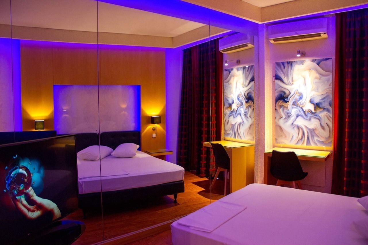 Una habitación de hotel moderna con una cama grande, un escritorio y una televisión.
