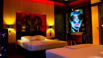 A hotel room with two beds, a desk, and a large mirror.