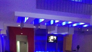 A modern indoor pool area with a seating area and a television screen. - Olympic Hotel – Adults Only (Piraeus)