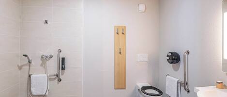 A modern bathroom with a shower, toilet, and sink.