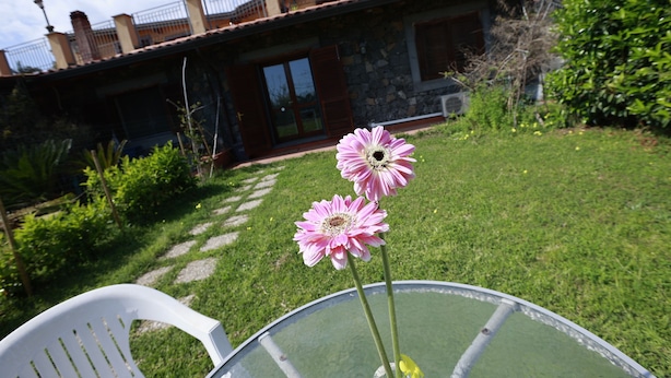 Ett hus med en fasad av sten, en glasdörr och en balkong.