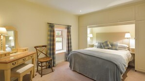 A bedroom with a bed, bedside tables, a dresser, a chair, and a window with curtains. - Weighbridge Cottage - a detached cottage with open fire and private garden (OBAN)