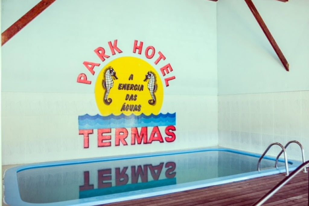 Zona de piscina con un cartel que dice 'Park Hotel A Energia das Águas Termas'.