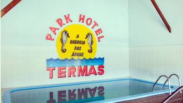 Zona de piscina con un cartel que dice 'Park Hotel A Energia das Águas Termas'.