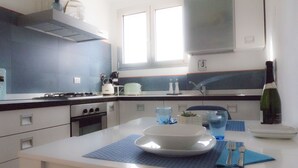 A modern kitchen with white cabinets, a stove, and a window above the sink. - Immerse Yourself in an Idyllic Situation (Bologna)