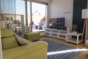A modern living room with a green sofa, a flat-screen TV, and a patterned rug. - Immerse Yourself in an Idyllic Situation (Bologna)