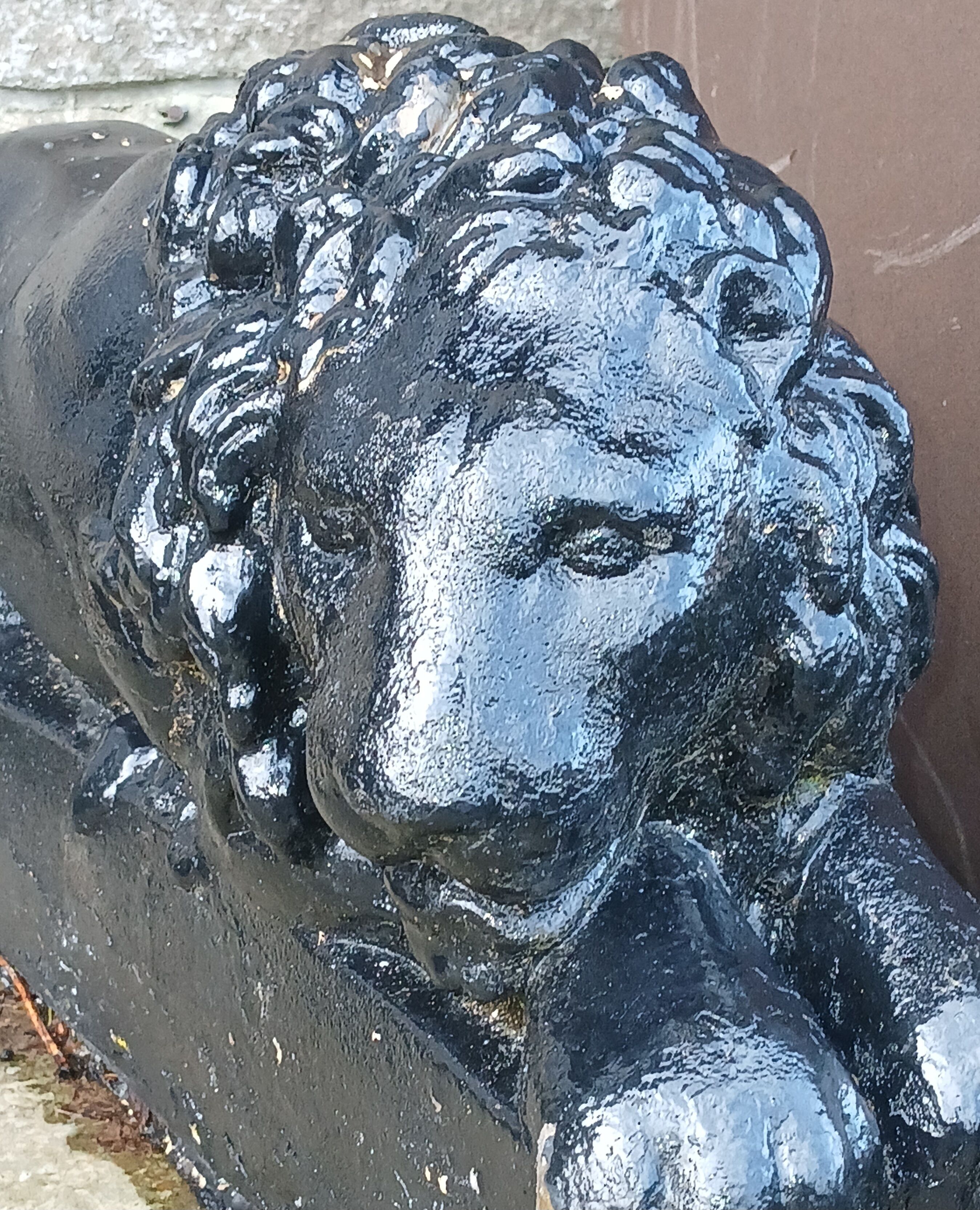 Um close-up de uma escultura de metal preto com detalhes intrincados e acabamento brilhante.