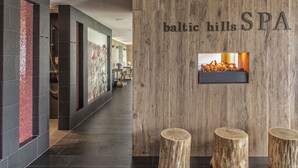 Un área de spa moderna con una pared de madera, dos taburetes de madera y un pequeño estante con velas.