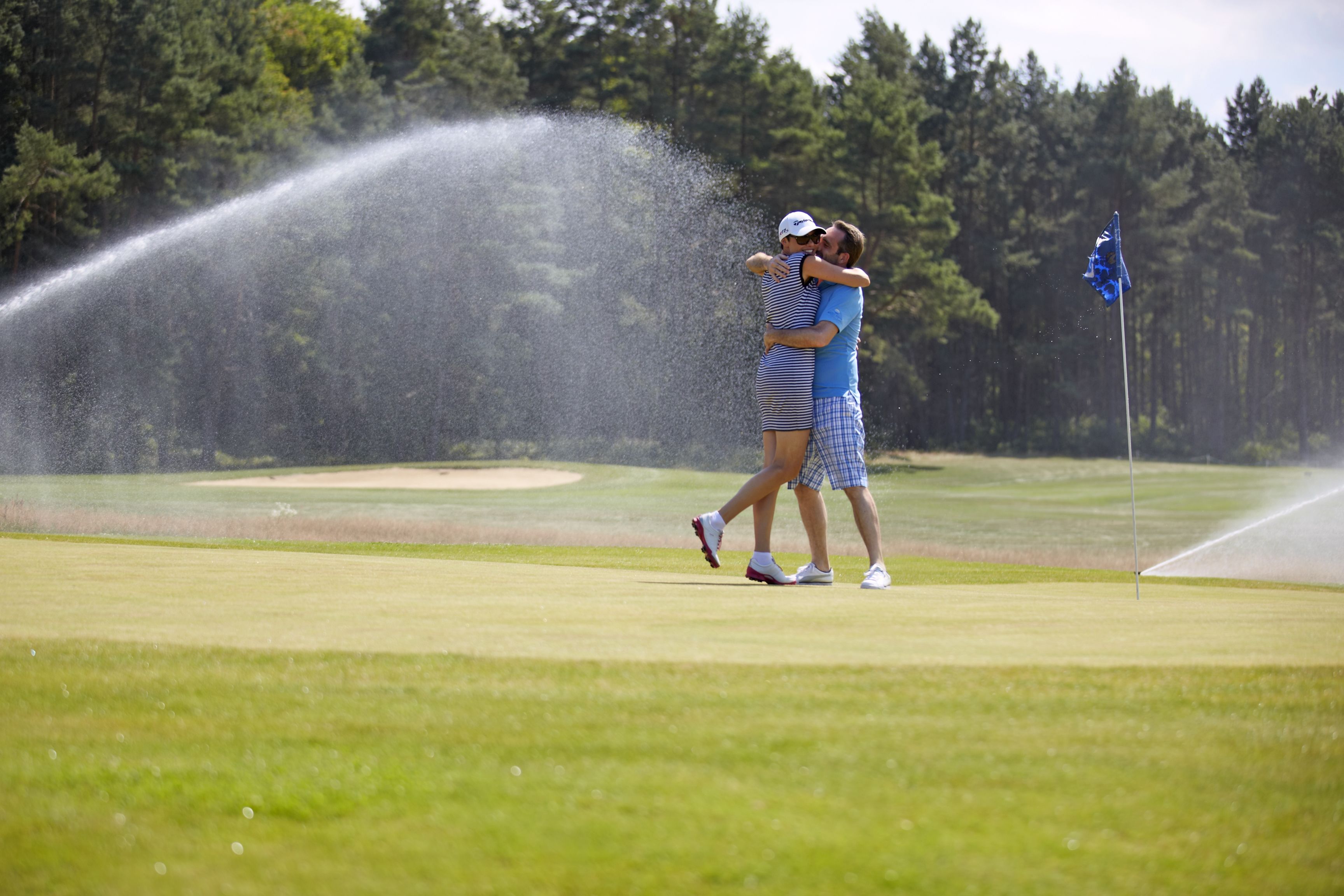 Un campo de golf con un sistema de riego en funcionamiento.