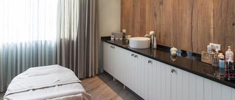 A modern bathroom with a wooden vanity, a large mirror, and a ceiling light fixture.